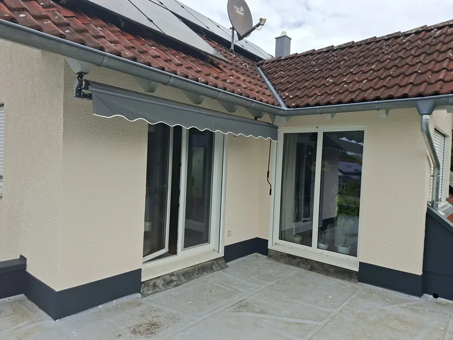 Fertige helle Fassade mit sauberer Terrasse nach der Übergabe