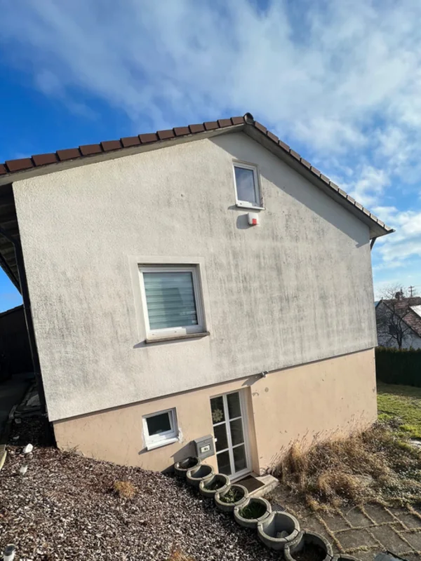 Fassade mit Algenstreifen und vergrautem Anstrich vor der Sanierung in Rottenacker