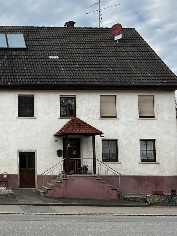 Verwitterte Altbaufassade mit Sockel vor der Sanierung in Rupertshofen